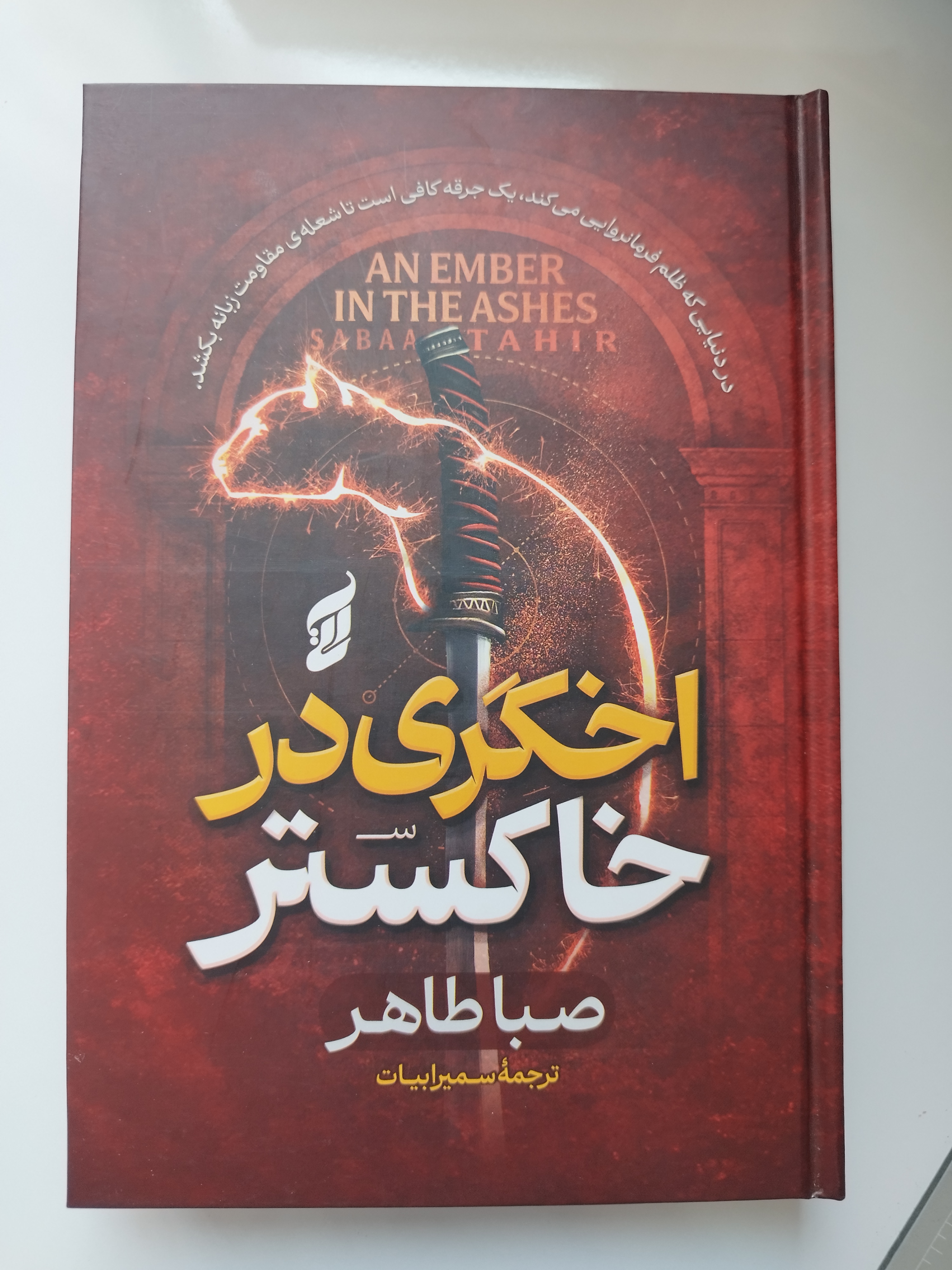کتاب اخگری در خاکستر جلد سخت لبه رنگی اثر صبا طاهر ترجمه سمیرا بیات نشر آتیسا